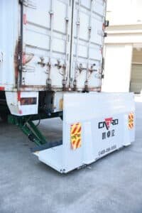 Refrigerated box truck at a loading dock with a hydraulic tail lift prepared for cold-chain cargo handling